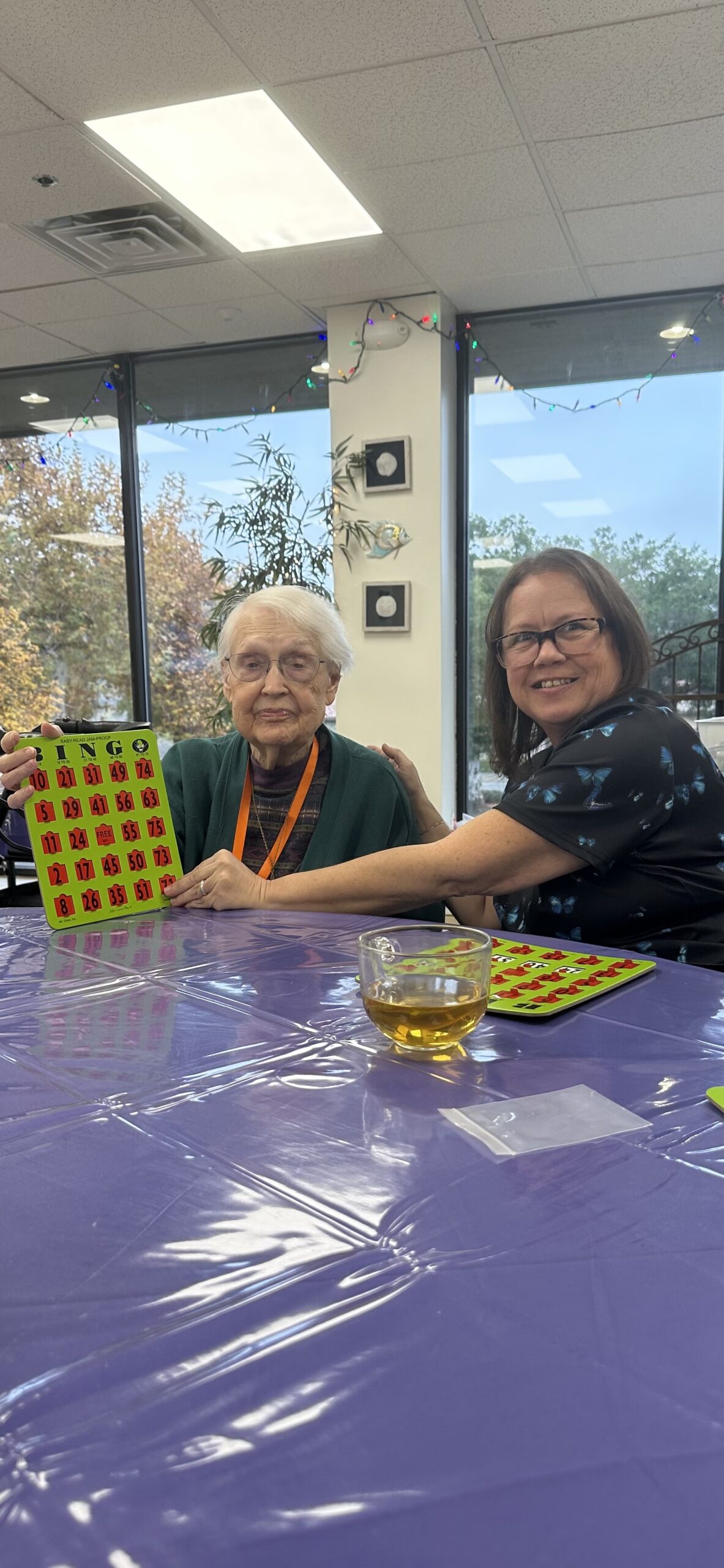 A participant showing off her bingo card with a staff member